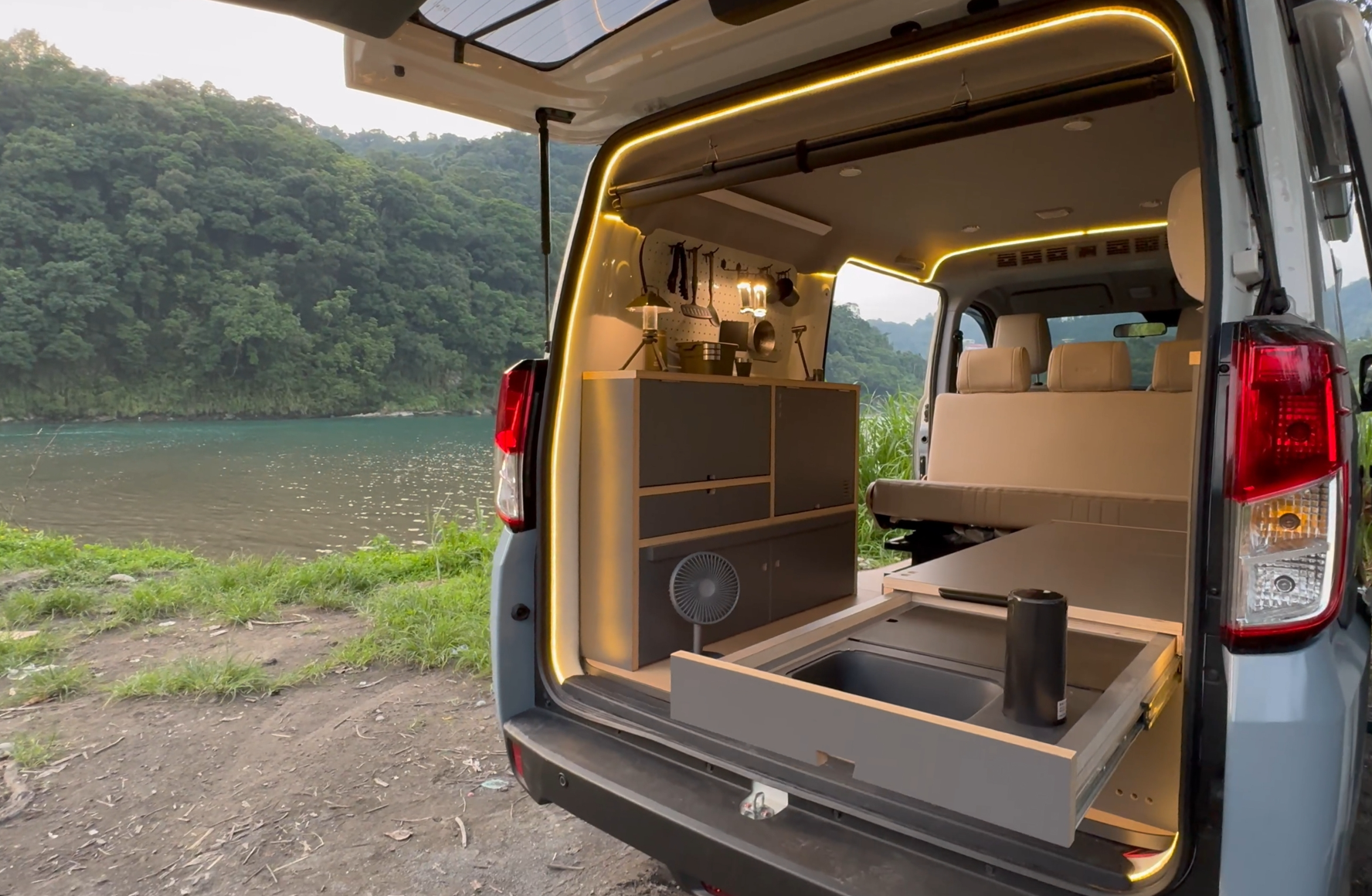野孩子 JSPACE 精緻水槽版露營車，湖畔車尾展示抽拉式水槽、深灰櫃體、洞洞板與暖色燈光