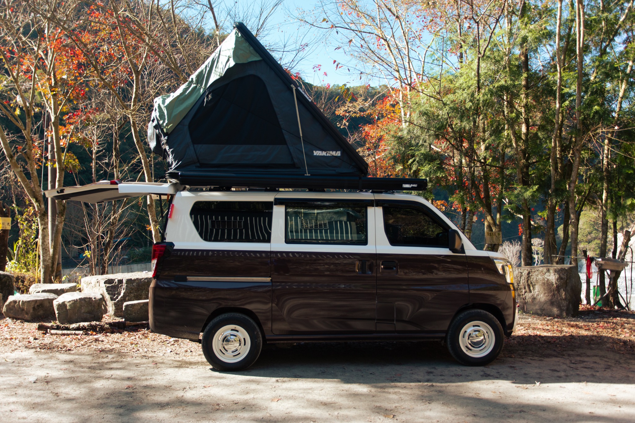 野孩子雙色 JSPACE 停在林間，車頂展開 YAKIMA 車頂帳，呈現完整帳篷與車身